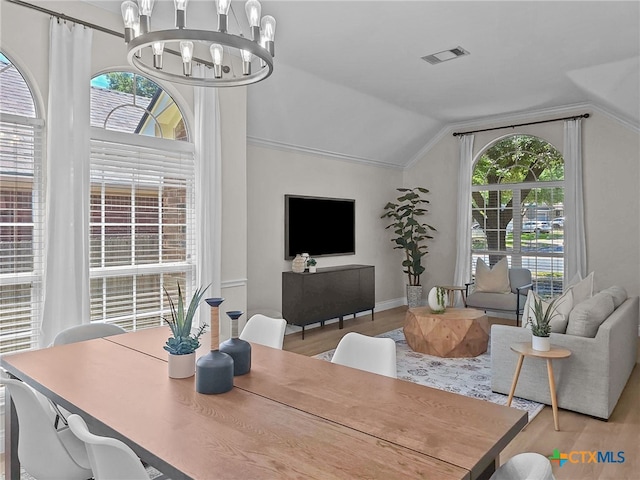13217 Armaga Springs Rd, Austin, TX 78727 - dining room featuring lofted ceiling, a chandelier, healthy amount of natural light, and wood finished floors