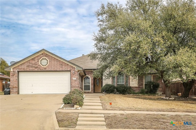 single story home with concrete driveway, brick siding, fence, and an attached garage