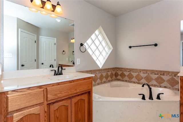 full bathroom with visible vents, a tub with jets, and vanity