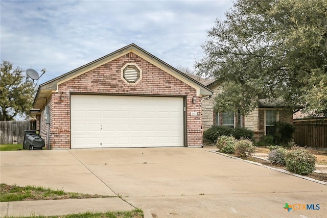 view of front facade featuring concrete driveway, brick siding, and fence