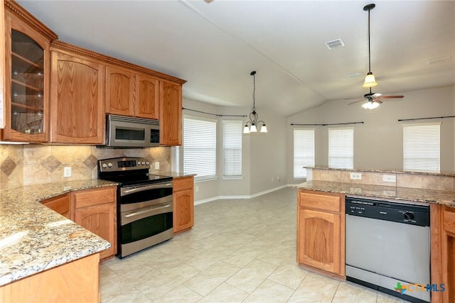 kitchen featuring stainless steel appliances, vaulted ceiling, hanging light fixtures, decorative backsplash, and glass insert cabinets