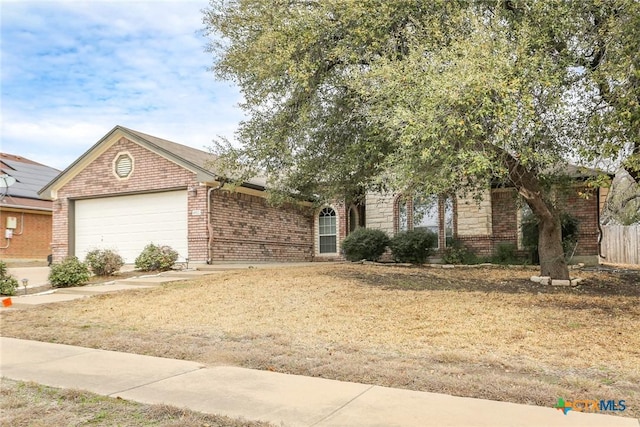 view of front of home featuring stone siding, brick siding, and an attached garage