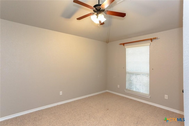 empty room featuring ceiling fan, baseboards, vaulted ceiling, and light colored carpet