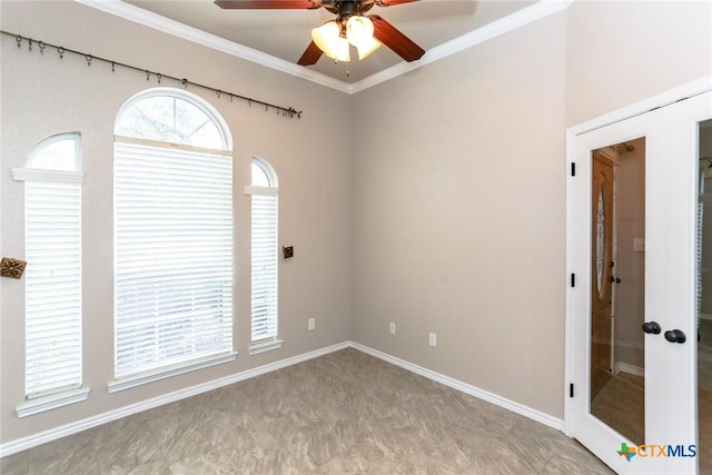 empty room featuring baseboards, ornamental molding, a ceiling fan, and french doors