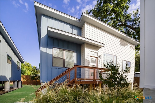 rear view of house with a lawn and a wooden deck