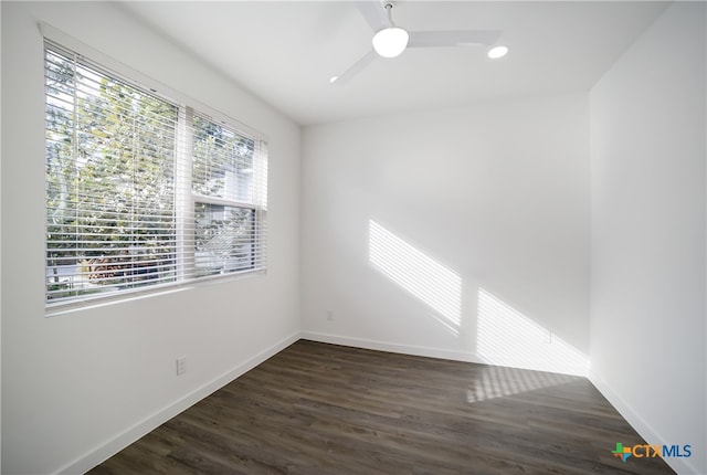 empty room with ceiling fan, dark hardwood / wood-style floors, and plenty of natural light