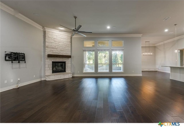 unfurnished living room featuring dark hardwood / wood-style flooring, ornamental molding, ceiling fan, and a stone fireplace