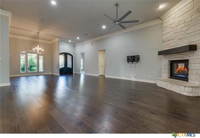 unfurnished living room featuring ceiling fan with notable chandelier, french doors, a stone fireplace, and dark hardwood / wood-style floors