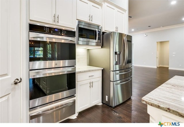 kitchen featuring light stone countertops, white cabinets, dark hardwood / wood-style floors, and appliances with stainless steel finishes