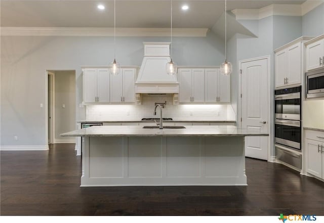 kitchen featuring decorative light fixtures and an island with sink