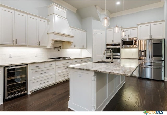 kitchen with sink, decorative backsplash, pendant lighting, wine cooler, and appliances with stainless steel finishes