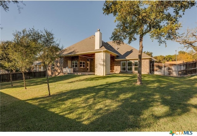 rear view of house featuring a yard