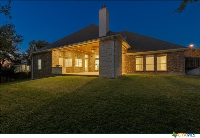 back of property with a patio area and a lawn