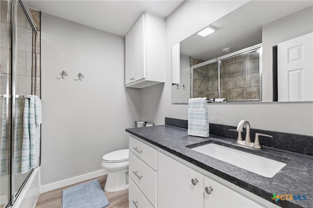 1113 W Port Dr, Port Mansfield, TX 78598 - full bathroom featuring vanity, wood finished floors, and bath / shower combo with glass door