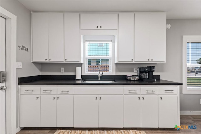 1113 W Port Dr, Port Mansfield, TX 78598 - kitchen with white cabinets, dark countertops, and wood finished floors