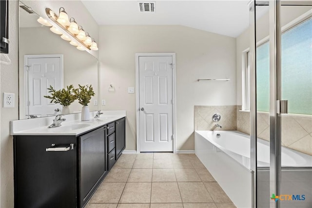 703 Curtis Dr, Killeen, TX 76542 - bathroom featuring double vanity, a bath, tile patterned flooring, and vaulted ceiling