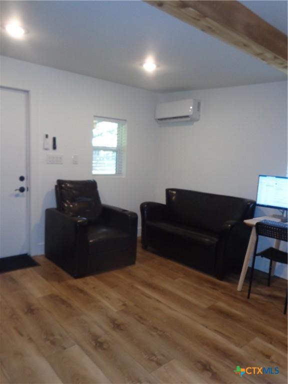 1009 Edgewater Fls, Canyon Lake, TX 78133 - living area with an AC wall unit and wood finished floors
