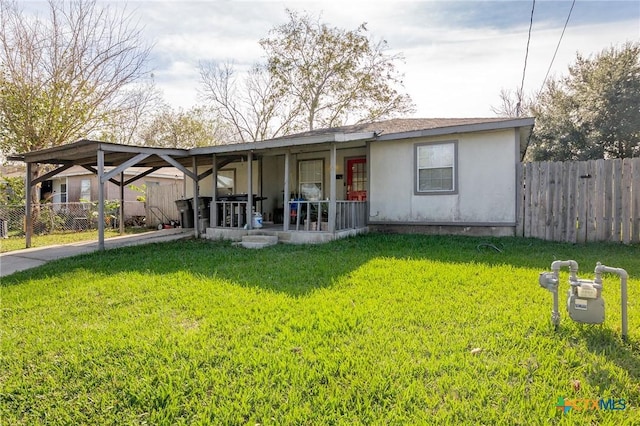 ranch-style house featuring a carport, a porch, and a front yard