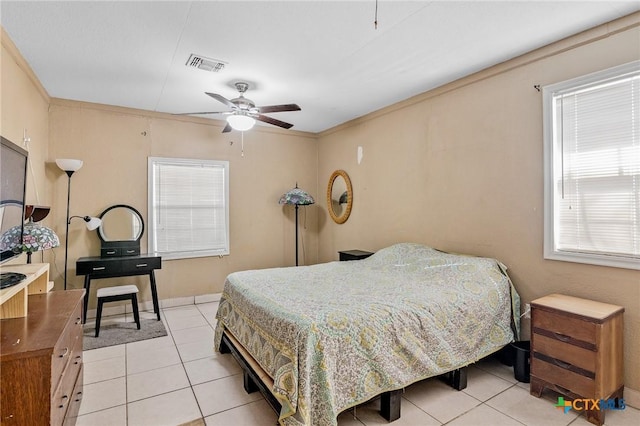 bedroom with ceiling fan, light tile patterned floors, and multiple windows