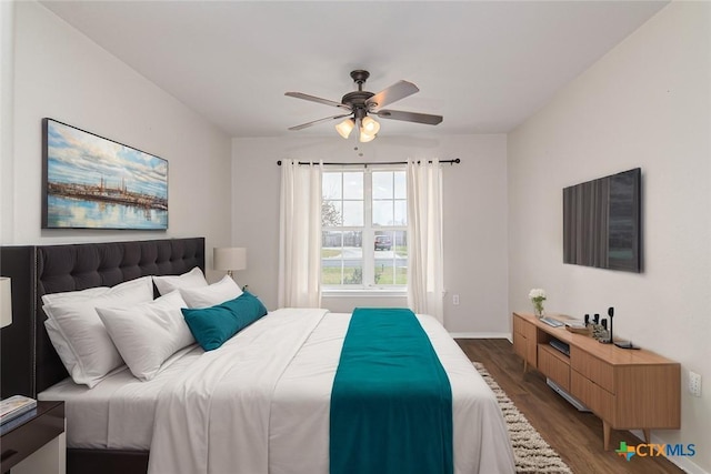 bedroom featuring dark wood-style floors, ceiling fan, and baseboards