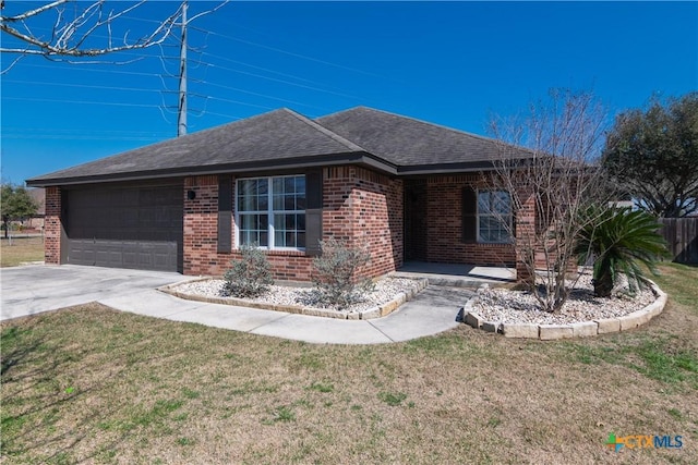 single story home featuring an attached garage, concrete driveway, brick siding, and a front yard