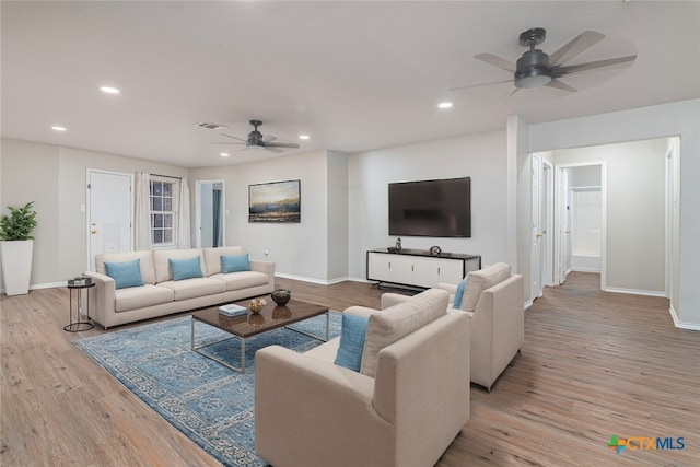 living room featuring recessed lighting, baseboards, visible vents, and light wood finished floors