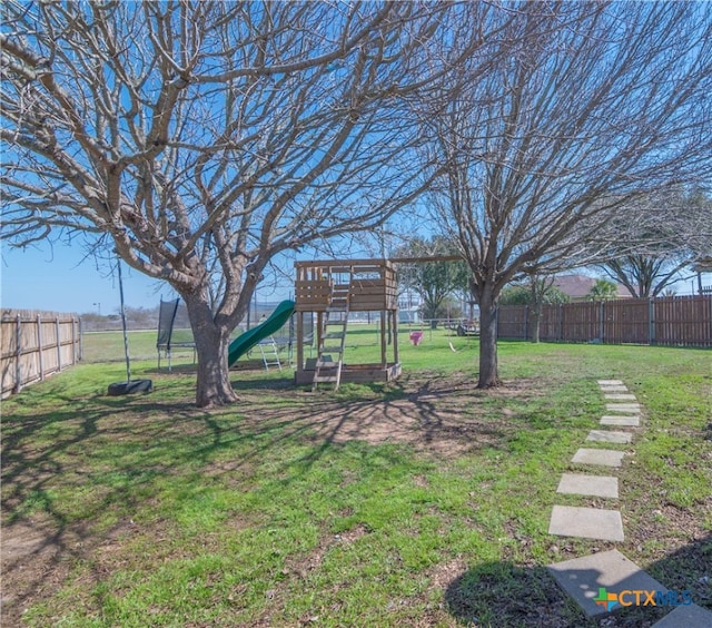 view of yard featuring playground community and fence