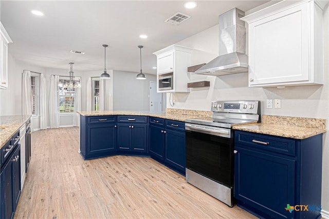 kitchen featuring stainless steel appliances, wall chimney range hood, blue cabinetry, and visible vents