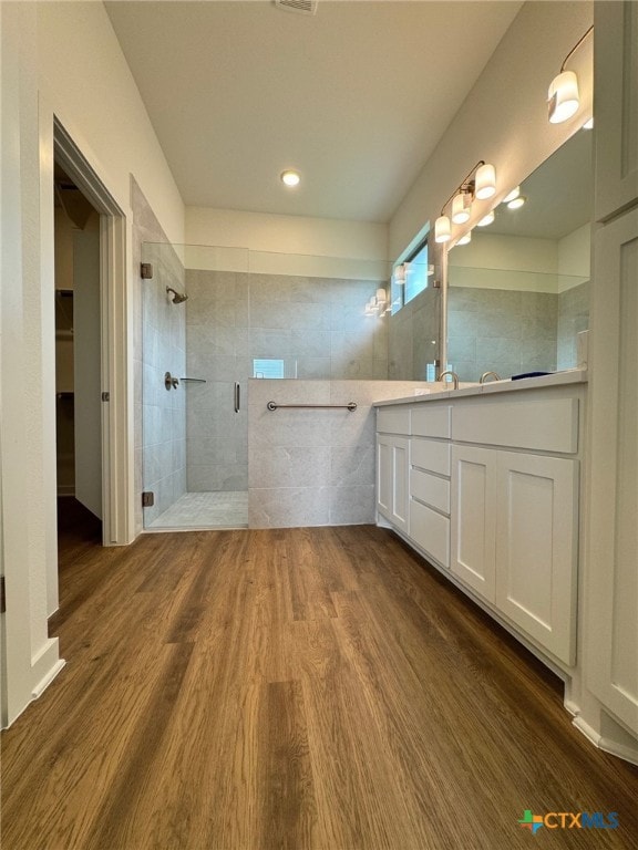 10826 Campsite Cv, Temple, TX 76502 - full bath featuring tiled shower, vanity, wood finished floors, and a walk in closet