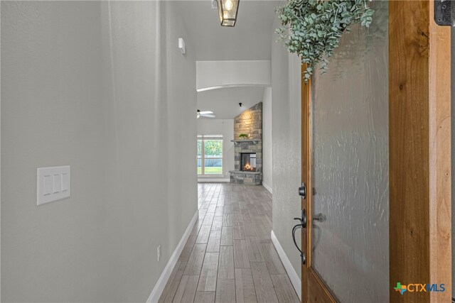 corridor with hardwood / wood-style flooring and vaulted ceiling