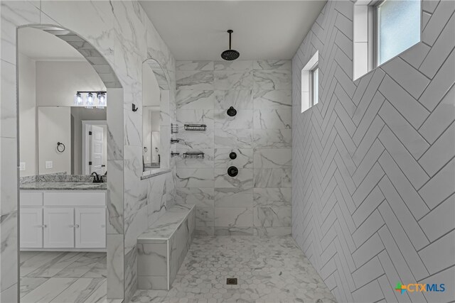 bathroom with vanity and a tile shower