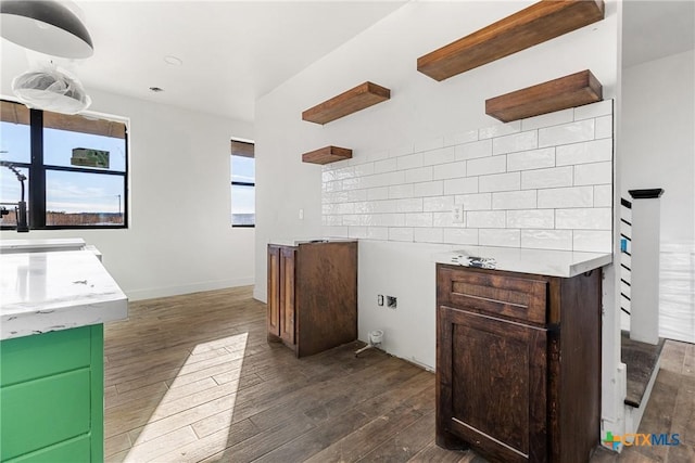 kitchen with backsplash, dark hardwood / wood-style flooring, and sink