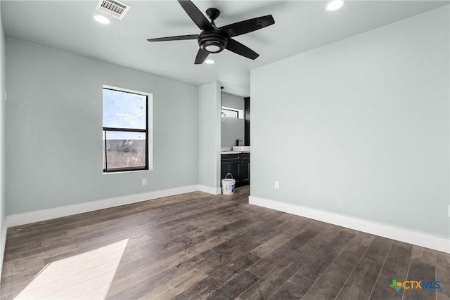 unfurnished bedroom featuring ceiling fan, dark wood-type flooring, and ensuite bathroom