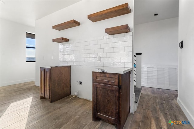 kitchen featuring dark hardwood / wood-style flooring and dark brown cabinetry