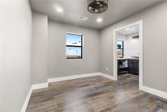 unfurnished room with dark hardwood / wood-style floors and bar area