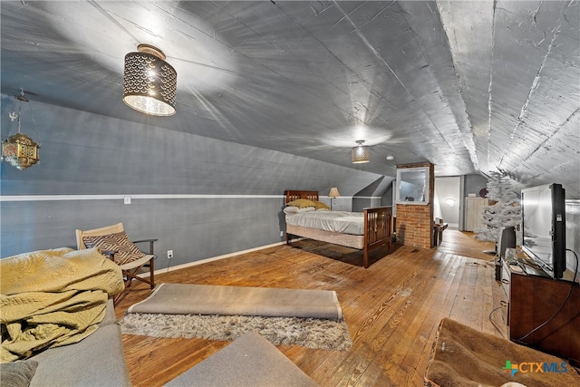 bedroom with vaulted ceiling and hardwood / wood-style flooring