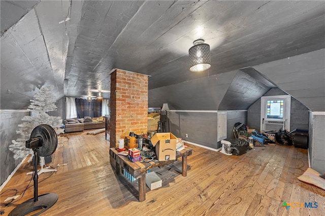 additional living space with hardwood / wood-style flooring and lofted ceiling