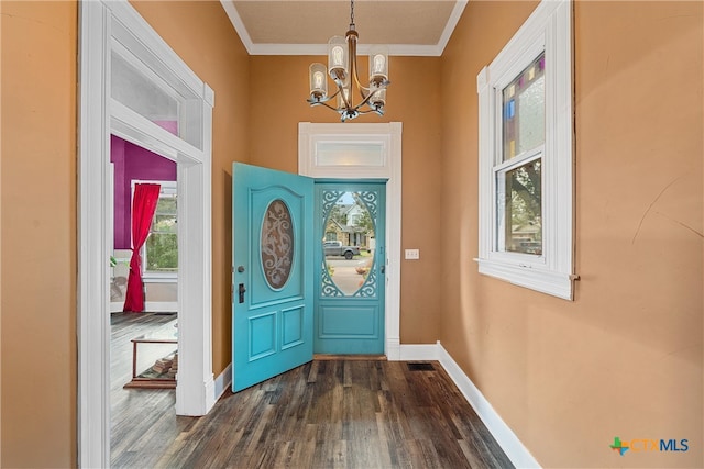 entrance foyer featuring ornamental molding, dark hardwood / wood-style floors, and an inviting chandelier