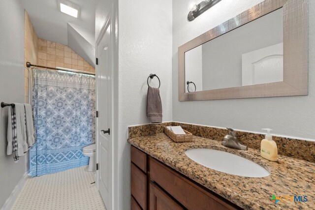 bathroom featuring vanity, toilet, and curtained shower