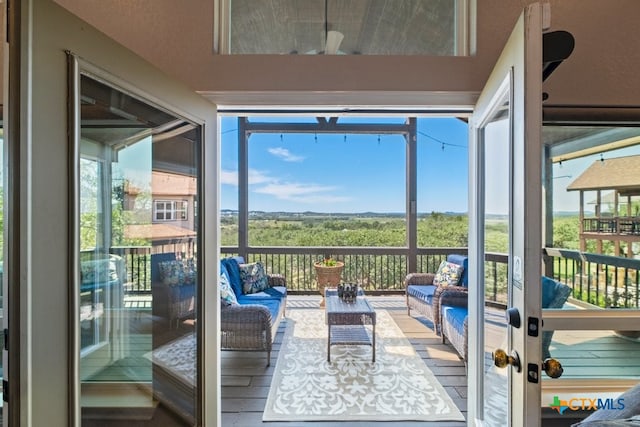 sunroom with an outdoor living space, plenty of natural light, and a ceiling fan