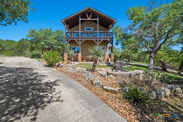 view of front of home with a balcony and asphalt driveway