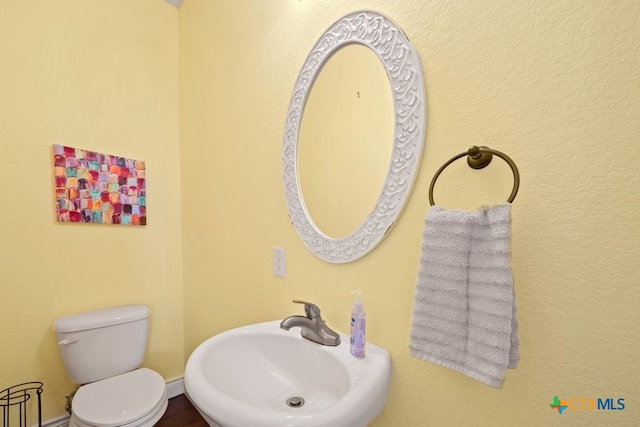half bathroom featuring a sink and toilet