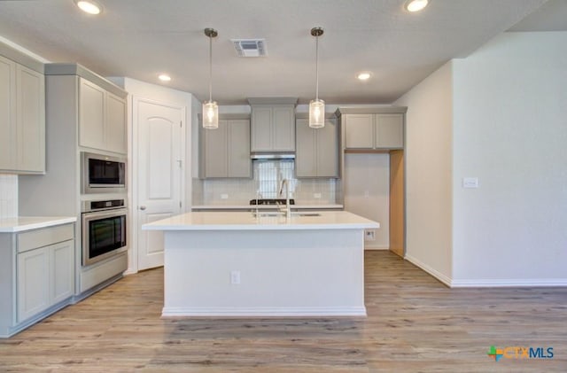 kitchen with stainless steel appliances, light hardwood / wood-style flooring, gray cabinetry, and sink