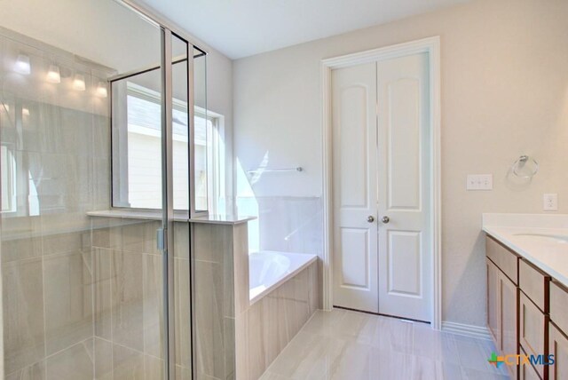 bathroom featuring tile patterned floors, vanity, and plus walk in shower