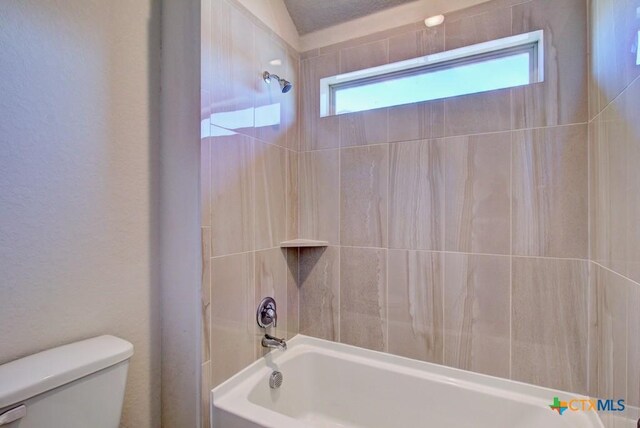 bathroom with toilet and tiled shower / bath