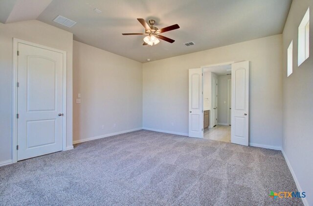 unfurnished bedroom featuring light carpet, vaulted ceiling, and ceiling fan