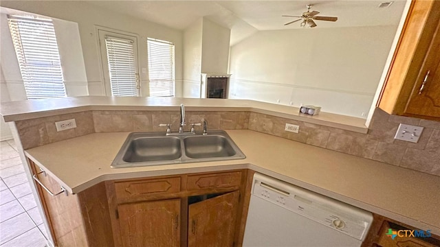 kitchen with kitchen peninsula, lofted ceiling, sink, and dishwasher