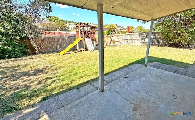 view of yard featuring a playground and a patio area