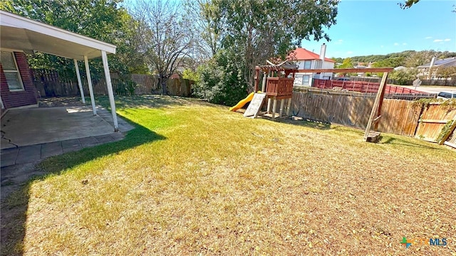 view of yard featuring a playground and a patio