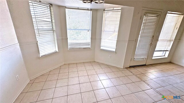 unfurnished dining area featuring light tile patterned flooring and an inviting chandelier